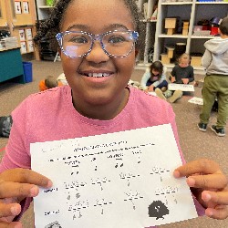 A second grade girl shows off her Thanksgiving ostinato pattern.